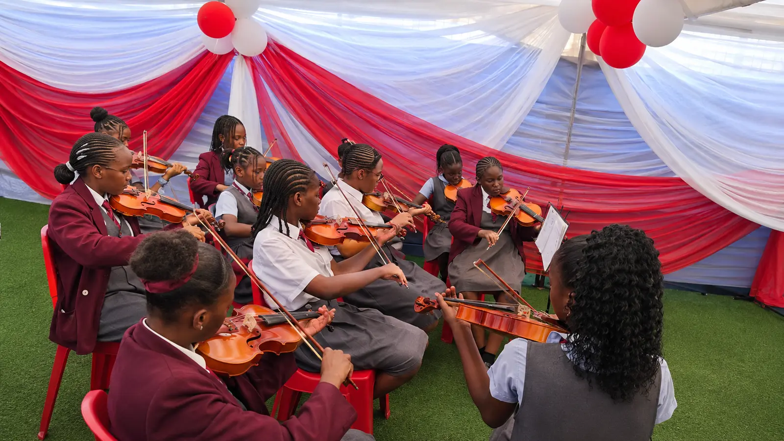 Petra Academy students performing together in a violin ensemble